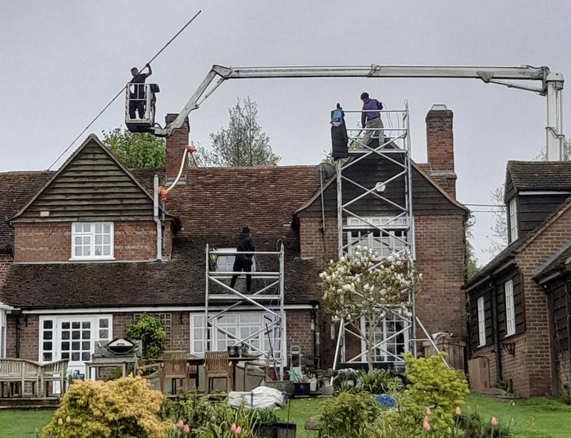 The Roof Moss Cleaners using cherry picker and scaffolding to clean roof safely and professionally in Witley, Surrey